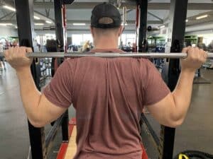 Where should I put the bar on my back when squatting