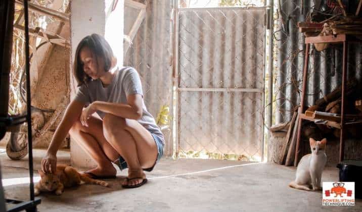 Squat asiatique et caresse un chat