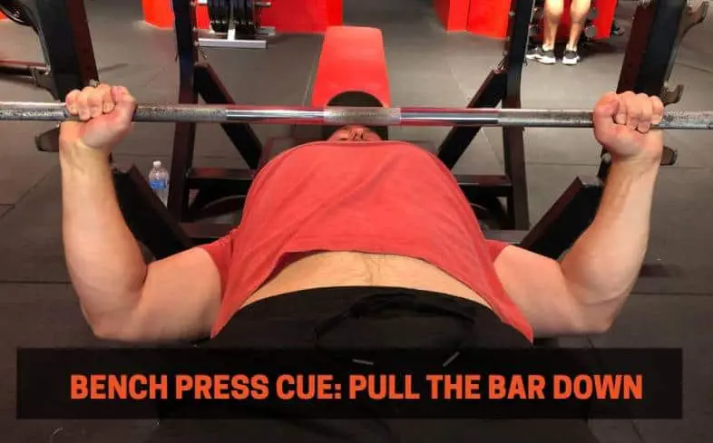 Bench press cue showing the lats engaged as the lifter pulls the barbell down toward the chest