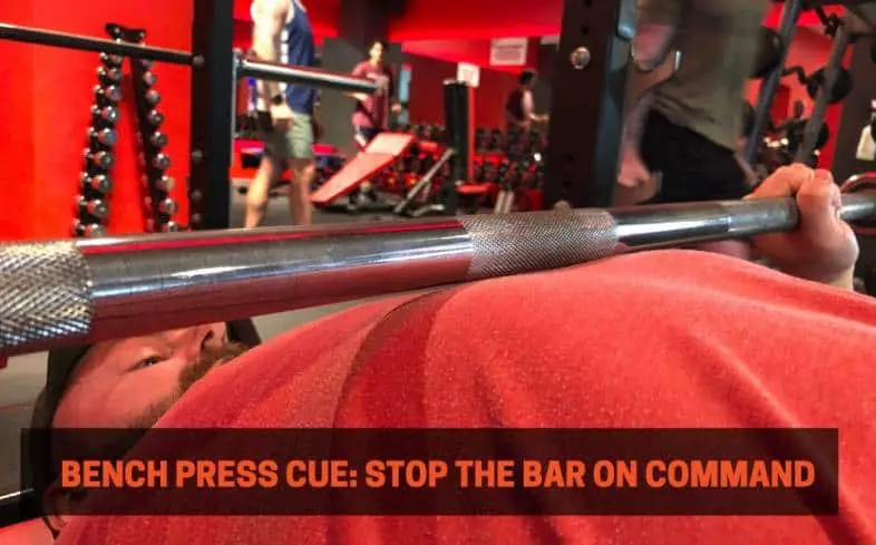 bench press cue showing the barbell stopping right on top of the chest