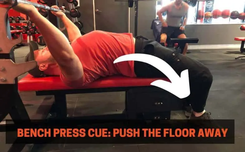Bench press cue showing pushing the floor away