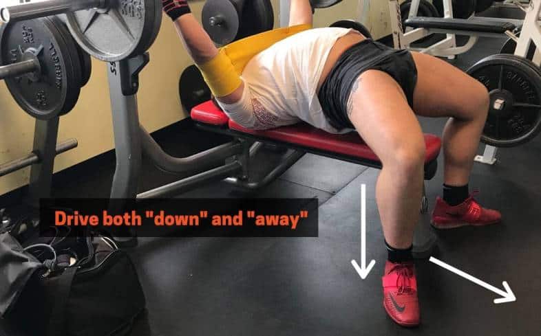 Arrows showing that you should press down and away from you when bench pressing