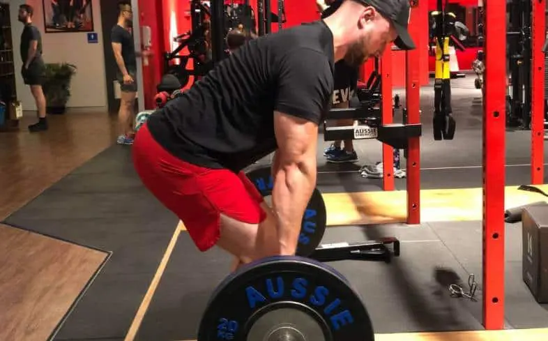A lifter wearing heeled squat shoes showing how body weight shifts forward while deadlifting.