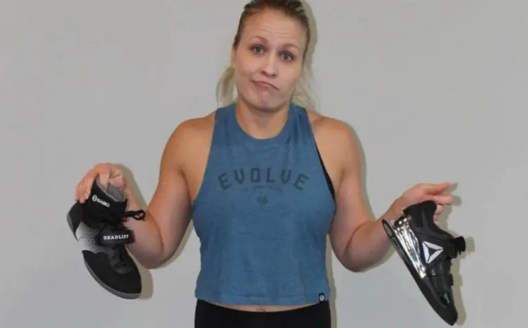 A lifting coach holds squat shoes for deadlifting.
