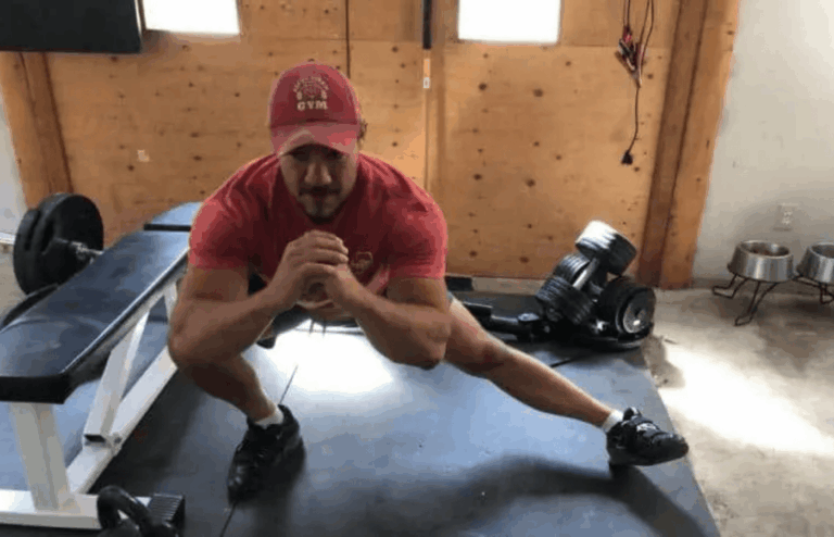 A powerlifting coach doing cossack squats.