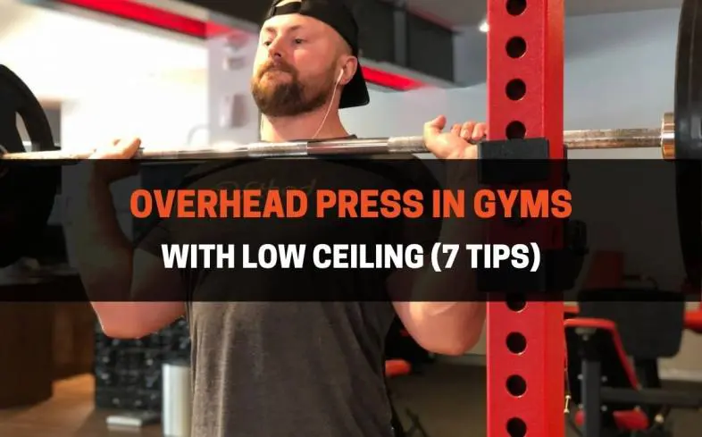you can overhead press with low ceilings by avoiding performing them in an upright stance