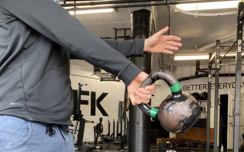 rotate the hand in a spiral motion to rack the kettlebell once it reaches the point of weightlessness