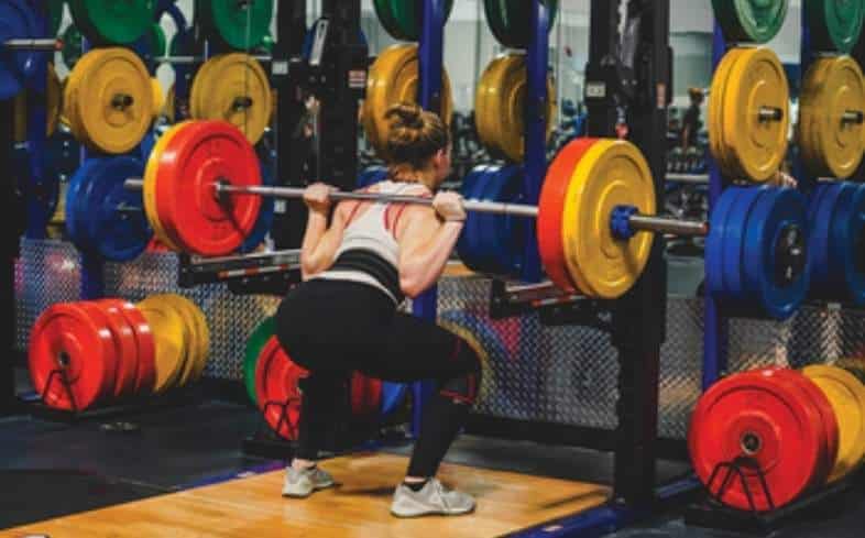 teen squatting at Crunch Fitness