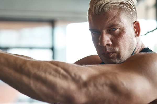 Close up of confident strong bodybuilder looking at you