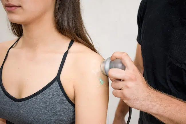Hand-holding-a-blue-ultrasound-probe-on-woman-s-sh-2022-11-14-18-02-05-utc