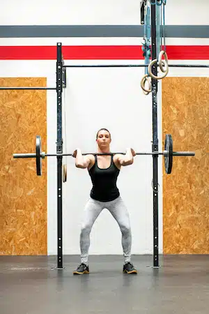 Young woman doing a front squat in a gym
