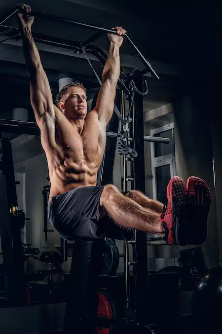A man doing ABS workouts on pull up bar.