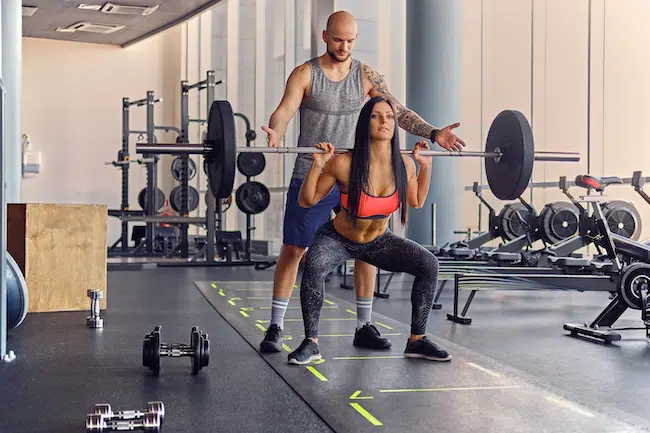 A-man-learning-a-woman-doing-squats-2021-08-29-06-07-00-utc