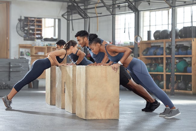 Group training, incline push up and bodyweight exercise, workout and fitness in a gym class with pl