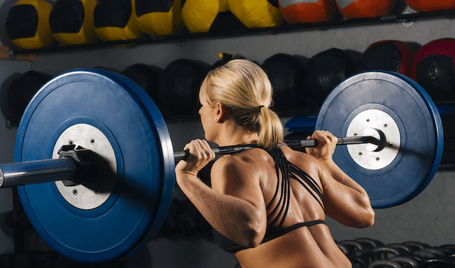 Young-woman-squatting-with-barbell-on-shoulders-in-2022-03-08-00-13-46-utc