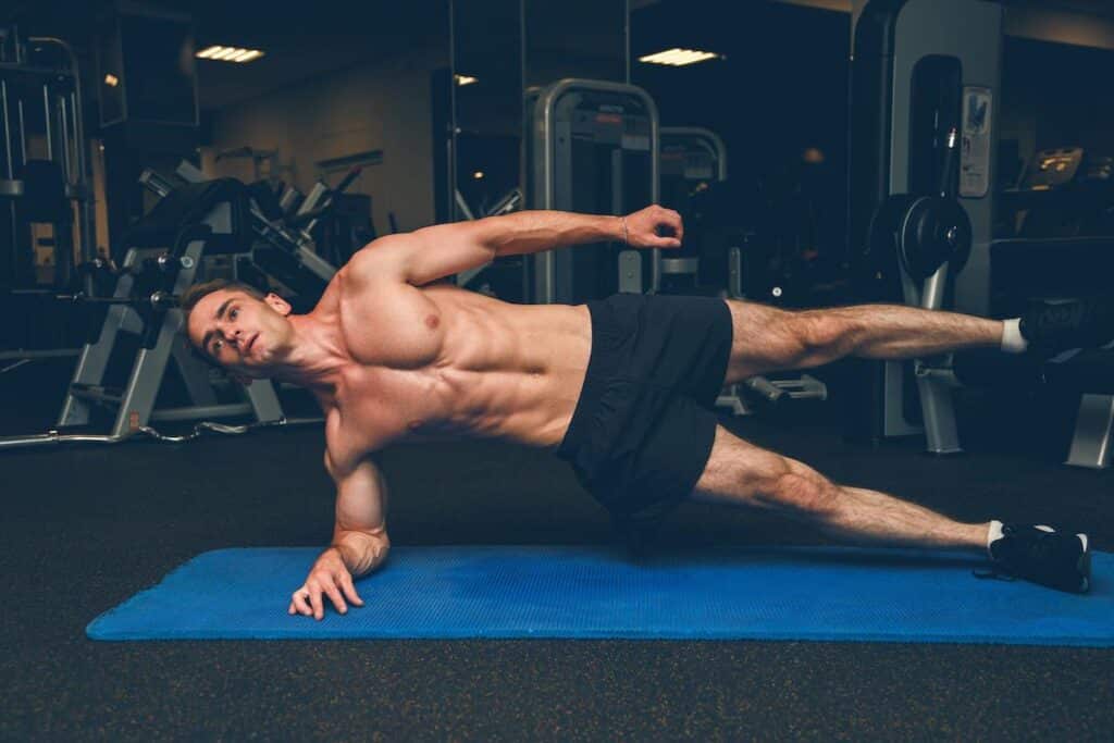 sportive young man doing side plank