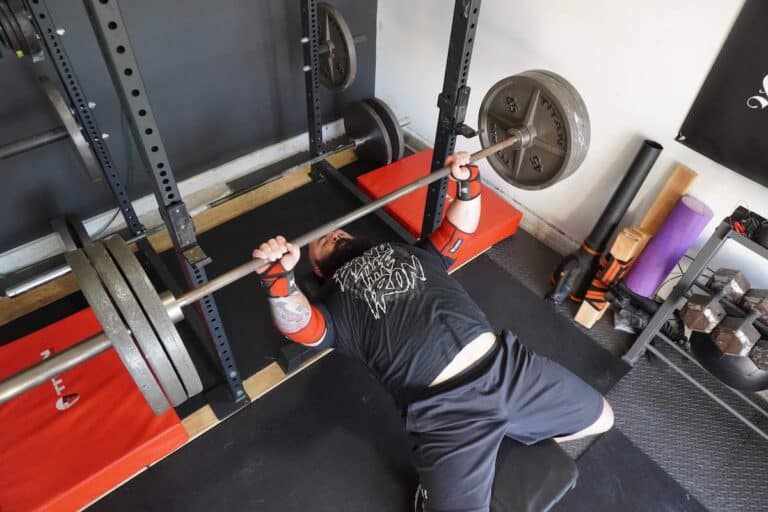 Our powerlifting coach demonstrates bench press with elbow sleeves from Iron Bull Strength. Photo by Powerlifting Technique.