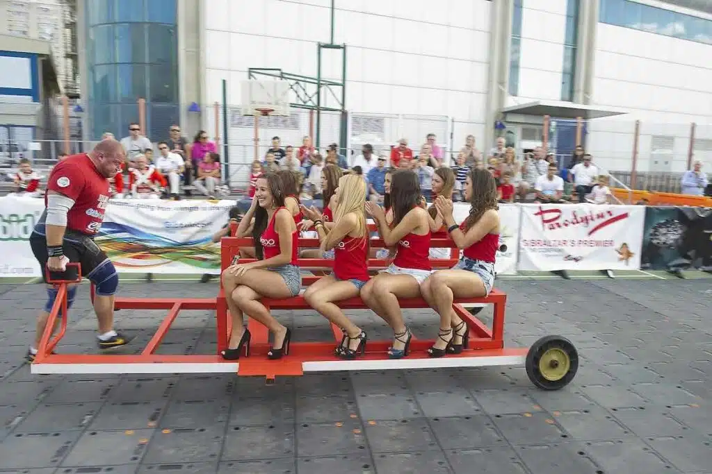 strongman-doing-famer-carry-with-girls-in-gilbraltar-competition