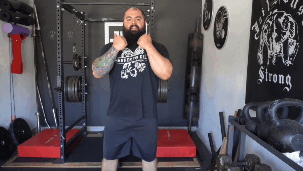A strength coach shows how to hold weights for the zercher squat.