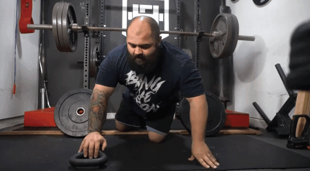 A strength coach shows how to do deficit pushups as a kettlebell chest workout.