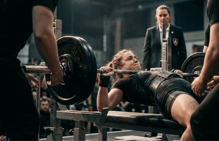 A female powerlifter behind a barbell.